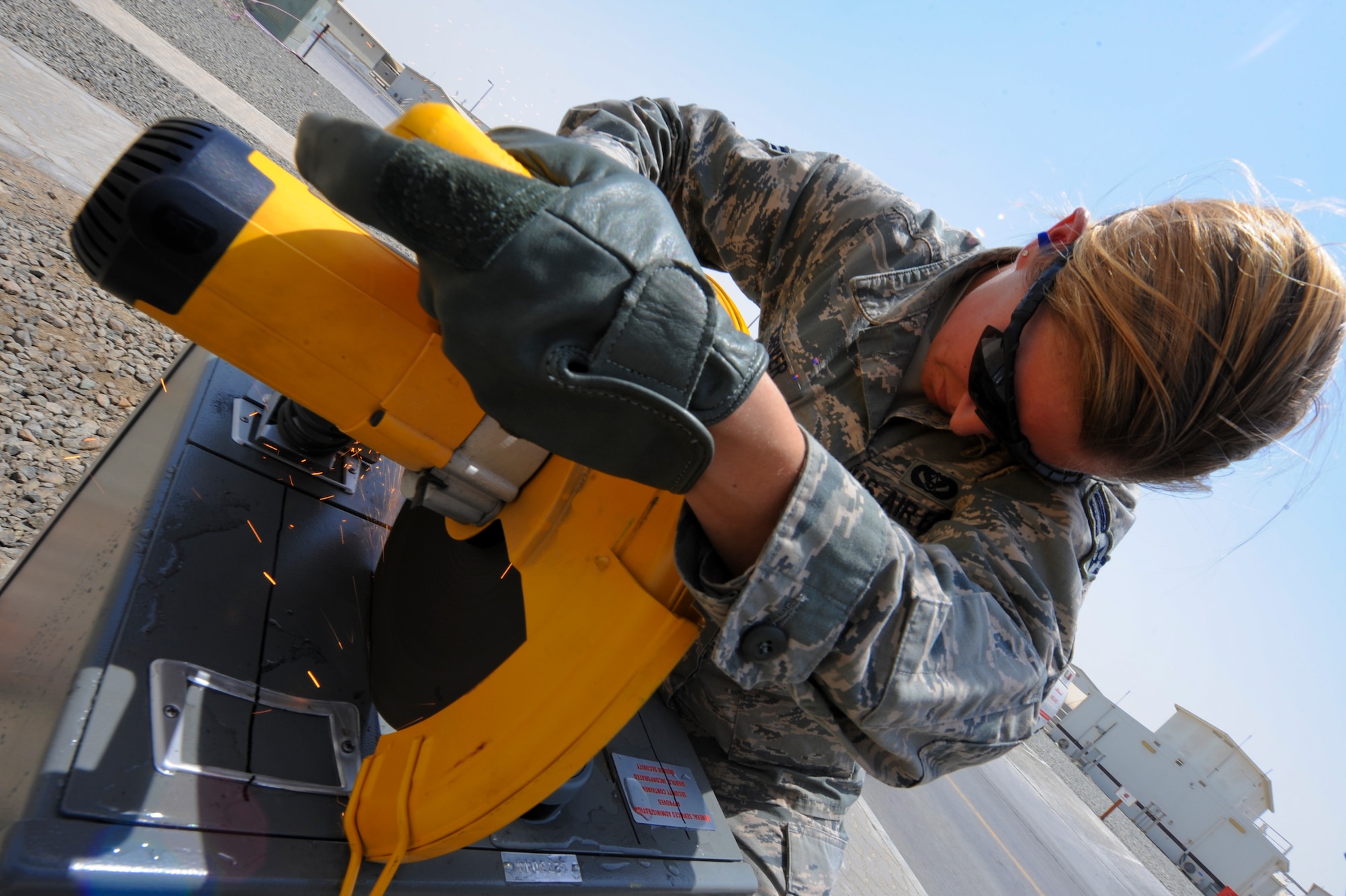 U.S. Airman 1st Class Megan Carver, 380th Expeditionary Civil Engineer Squadron locksmith, saws into a safe at an undisclosed location in Southwest Asia July 2, 2013.  If the safe is not empty, Carver must ensure that she can open the safe without damaging any of the contents inside. (U.S. Air Force photo by Staff Sgt. Joshua J. Garcia)