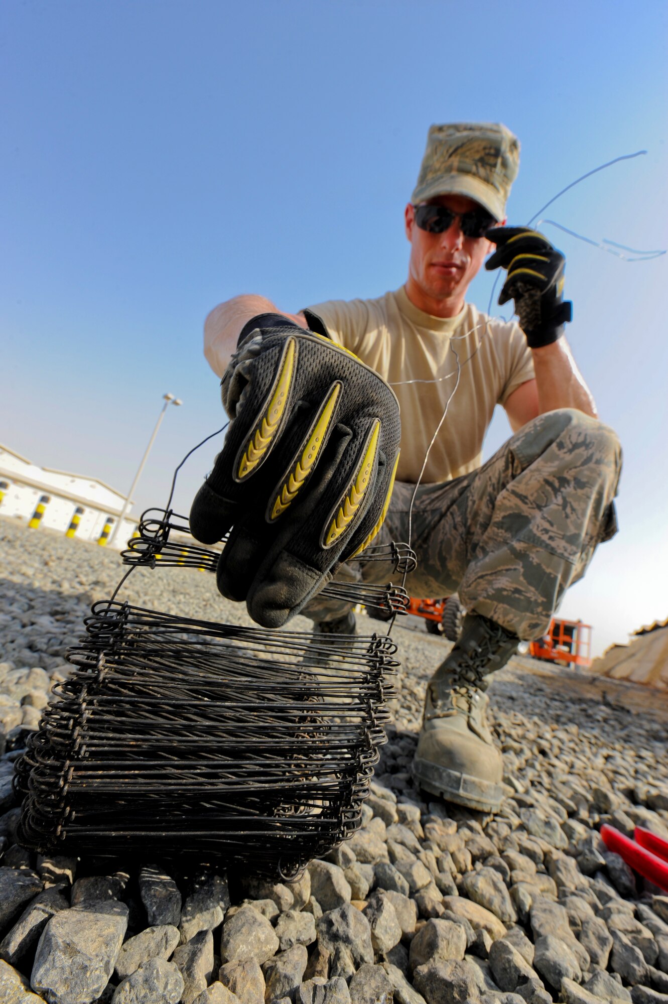 U.S. Air Force Airman 1st Class David Johnson, 380th Expeditionary Civil Engineer Squadron structures apprentice, pulls wire ties from a tie bundle at an undisclosed location in Southwest Asia July 2, 2013. The wire ties will be used to re-secure tent flies in tent city. Johnson hails from Duluth, Minn., and is deployed from Joint Base McGuire-Dix-Lakehurst, N.J. (U.S. Air Force photo by Staff Sgt. Joshua J. Garcia) 