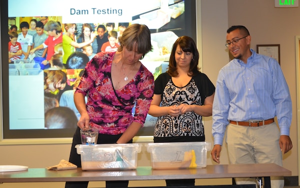 ALBUQUERQUE, N.M., -- Ariane Pinson, left, and Luis Pulido, Team III members, test different types of materials to determine how long and how well these materials hold up against water as part of their STEM presentation.