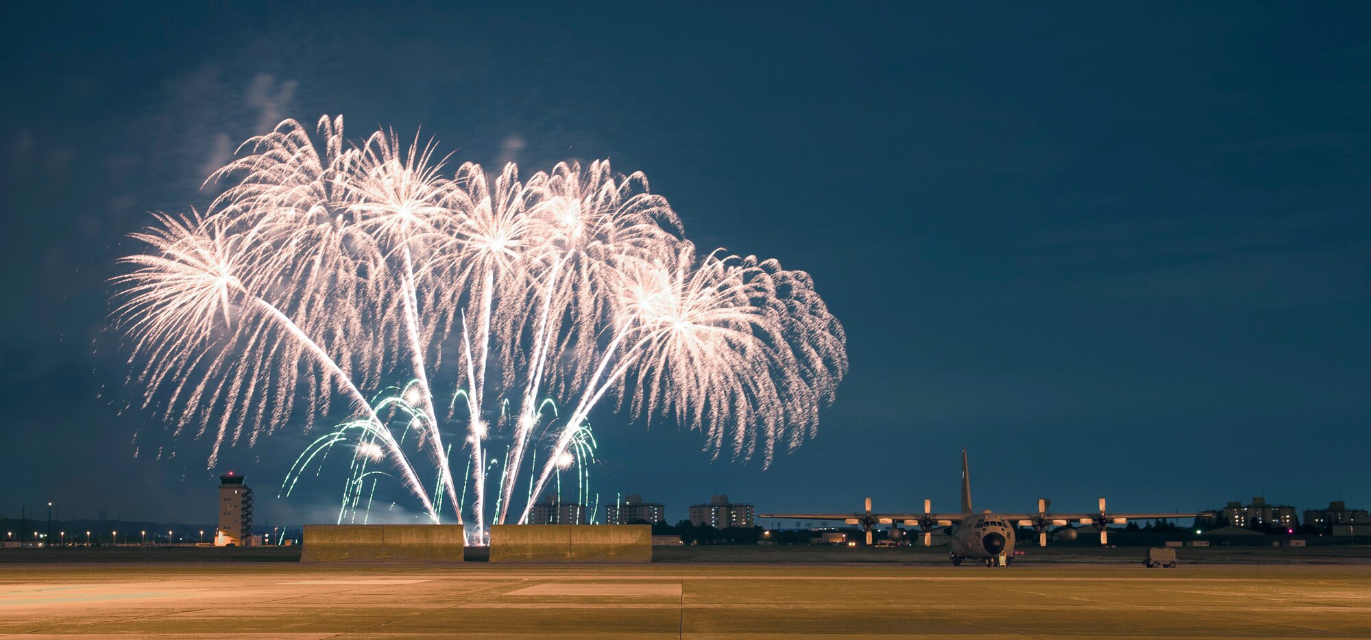 Fireworks light up the sky and a nearby C-130 on the flightline at Yokota Air Base, Japan, July 4, 2013 during the fourth of July celebration. The installation hosted a number of events throughout the day, which culminated with a performance by the Lt. Dan Band and the firework display to celebrate the holiday.  (U.S. Air Force photo by Senior Airman Michael Washburn/released)