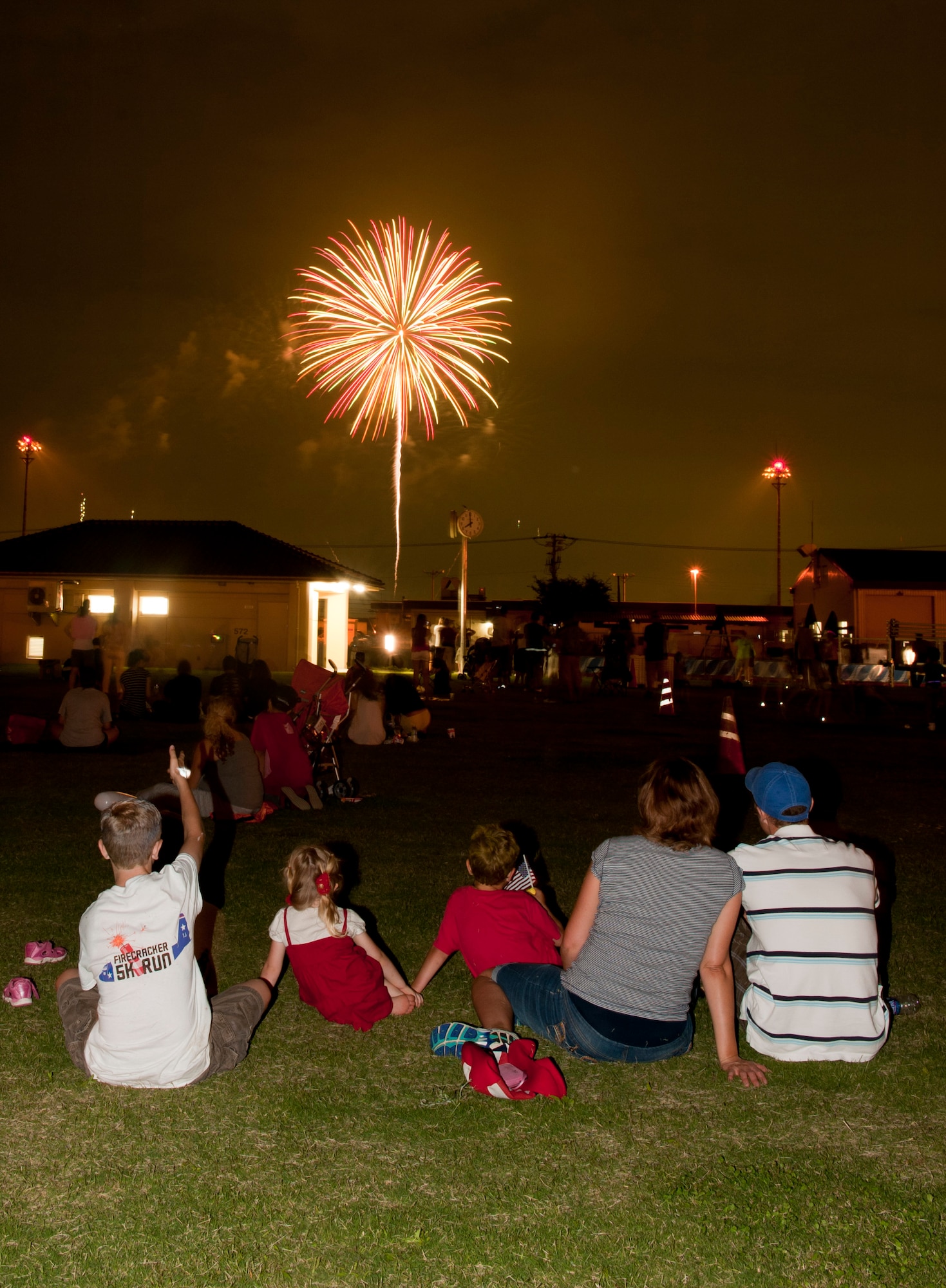 Members of the Yokota Air Base community watch fireworks in the sky above the flightline at Yokota Air Base, Japan, July 4, 2013.  The installation hosted a number of events throughout the day, which culminated with a performance by the Lt. Dan Band and the firework display to celebrate the holiday.  (U.S. Air Force photo by Senior Airman Michael Washburn/released)