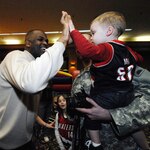 Portland Trail Blazers head coach, Nate McMillan, gives a high-five to Jackson Creswell at the "Make It Better Holiday Carnival" at the Memorial Coliseum, Feb. 9. Jackson, and father, Sgt. Ryan Creswell, of Bravo Co., 41 Special Troops Battalion, and his wife Christina, and daughter Emma, spoke to McMillan before handing their camera to a bystander to take a picture of the group. Hosted by the Portland Trail Blazers NBA basketball franchise, the event honored military members, giving them a chance to meet with Trail Blazers team members.