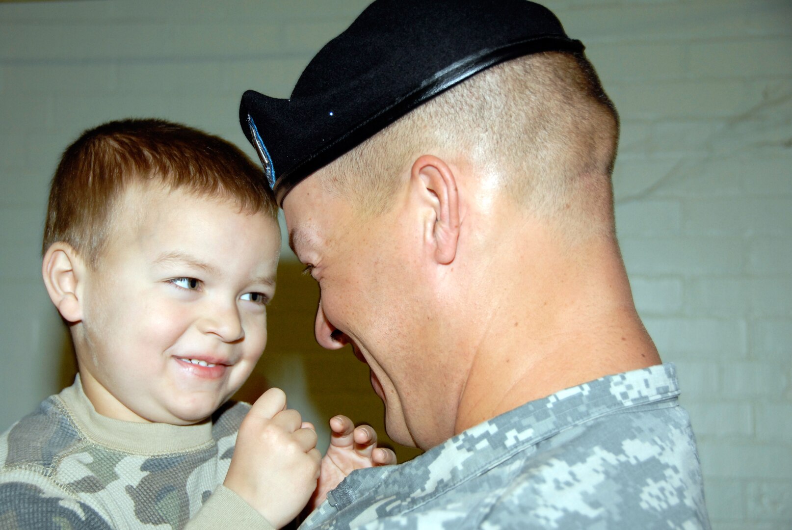 Tyler Dudley, left, is lovingly held by his dad, Army Capt. Brian Dudley, right, at the departure ceremony of the 363rd Explosive Ordnance Disposal Company from the National Guard Armory in Coolidge, Ariz., on Saturday, February 21, 2009. The senior Dudley commands 24 other Soldiers responsible for ordnance removal in Iraq and Afghanistan for the coming year.