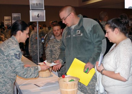 Air National Guard Tech Sgt. Shannon Pingitore, a member of Joint Forces Headquarters-New York Human Resources Directorate, provides Army National Guard Spec. Michael Anderson Jr. with information about full time employment opportunities in the National Guard during the New York Army National Guard Yellow Ribbon Reintegration Program meeting at the Rochester Riverside Convention Center, Feb. 21.