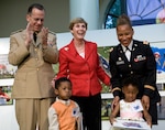 Navy Adm. Mike Mullen, chairman of the Joint Chiefs of Staff, and his wife Deborah, center, present commemorative books "For Children of Valor" to U.S. Army Capt. Marissa Alexander and her twin children Avery and Alaya at Arlington National Cemetery, Va., May 15, 2009.