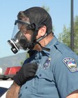 COLORADO SPRINGS, Colo. - Colorado Springs Police Department Officer J. W. Reutner dons a gas mask following a simulated chemical attack during the Coalition Warrior Interoperablity Demonstration June 16. The exercise, simulating a bomb and chemical attack in Colorado Springs, brought together members of U.S. Northern Command, the city of Colorado Springs and the University of Colorado at Colorado Springs first responders to respond to the exercise while simultaneously testing new technologies to make communicating between the groups more efficient. (U.S. Air Force photo by Staff Sgt. Thomas J. Doscher)