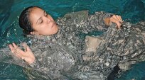 Sgt. Lauren Aldaco, force protection noncommissioned officer, U.S. Army North, attempts to create pockets of air inside her Army Combat Uniform trousers to use as a floatation device during Water Survival training at the Jimmy Brought Fitness Center indoor pool, at Fort Sam Houston June 18. The techniques the Soldiers learned during the training are used as part of the Army’s Water Survival Training Curriculum 21 – 21. 

