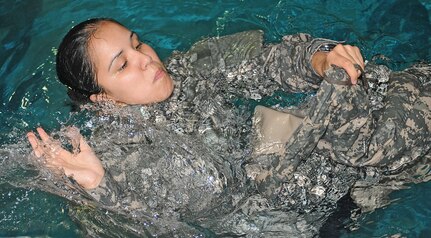 Sgt. Lauren Aldaco, force protection noncommissioned officer, U.S. Army North, attempts to create pockets of air inside her Army Combat Uniform trousers to use as a floatation device during Water Survival training at the Jimmy Brought Fitness Center indoor pool, at Fort Sam Houston June 18. The techniques the Soldiers learned during the training are used as part of the Army’s Water Survival Training Curriculum 21 – 21. 

