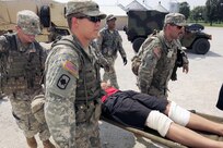 U.S. Soldiers with Alpha Company, 4th Battalion, 118th Infantry Regiment carry a simulated wounded civilian to a hospital July 15, 2010, at Camp Atterbury, Ind., as part of Vibrant Response 10.2. Vibrant Response, a U.S. Northern Command exercise for Chemical, Biological, Radiological, Nuclear and High-Yield Explosive Consequence Management Response Force 10.2, focuses on Department of Defense support of civil authorities in a consequence management role. (U.S. Air Force photo by Airman 1st Class Samuel W. Goodman/Released) 
