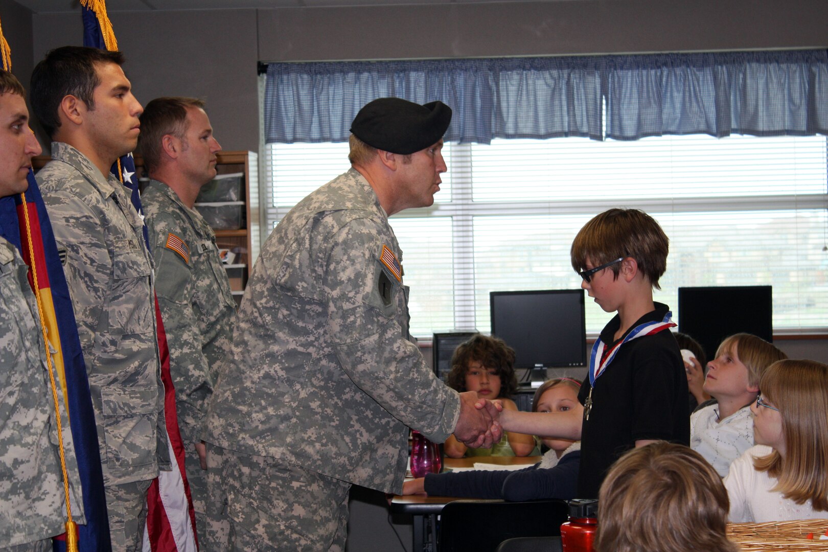 Capt. Derwin Allen acknowledges his nine-year-old son Colby after placing the Yellow Ribbon Program's hero medal around his neck during a ceremony in Colby's fourth-grade class at Lone Tree Elementary School on June 2, 2009. The hero medal acknowledges the sons and daughters of deployed parents. Colby's father was deployed to Afghanistan for nine months and he did not see him for a year.