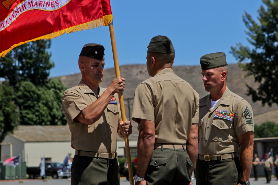 Lieutenant Col. Shawn Beltran, (left) the incoming commanding officer of 5th Battalion, 11th Marine Regiment, and a native of Wichita Falls, Texas, takes the battalion colors from Lt. Col. David Everly, (center) the outgoing commanding officer, and a native of Inglewood, Calif., during a change of command ceremony at Camp Las Pulgas here, June 28, 2013. Everly served for two years as the battalion's commanding officer and said leading and being in command of Marines is one of the greatest honors.