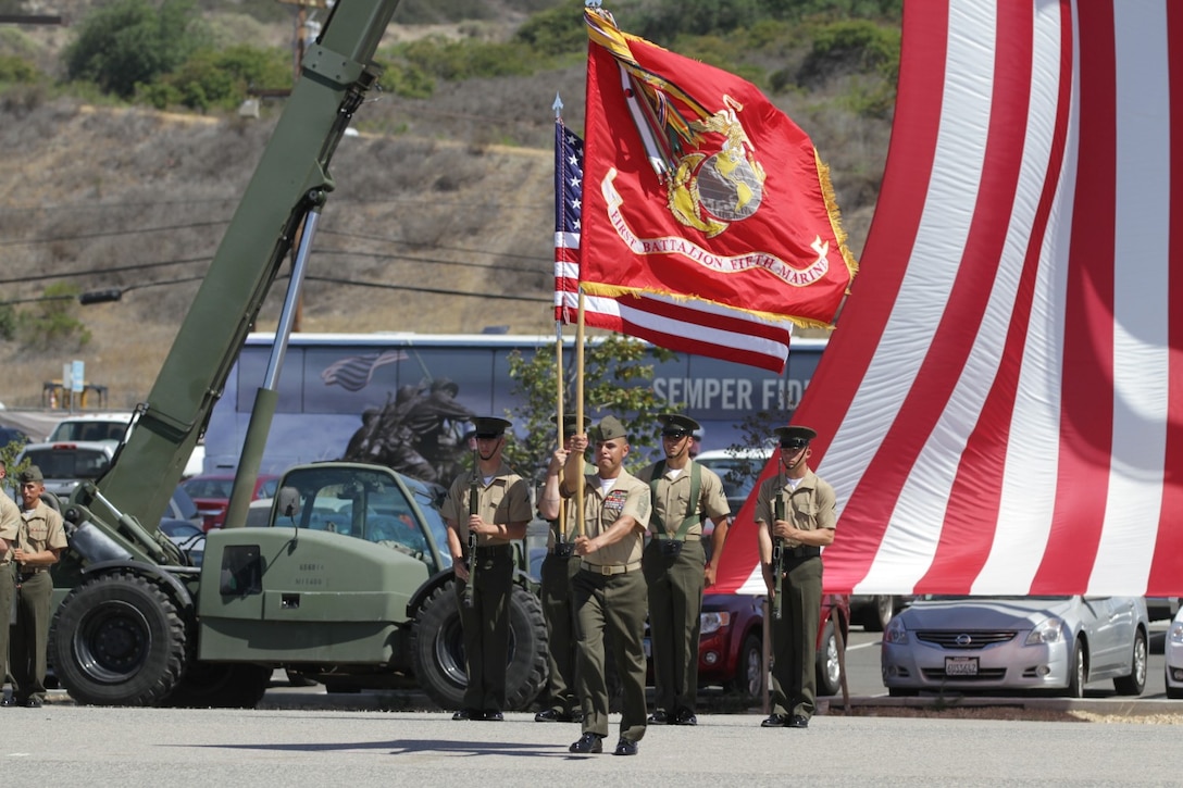 Sergeant Maj. Rudy Gonzales, the sergeant major of 1st Battalion, 5th Marine Regiment, carries the battalion colors to Lt. Col. Terry Johnson, the outgoing commanding officer of 1st Bn., 5th Marines, during a change of command ceremony at the Camp San Mateo parade deck here, June 28, 2013. Johnson, a native of Palo Pinto, Texas, will be attending a fellowship at Yale and said his battalion is going into good hands with Matthews.