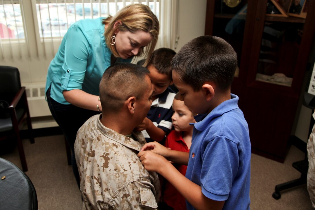 130701-M-YG378-013 MARINE CORPS BASE CAMP PENDLETON, Calif. (July 1, 2013) Newly promoted Lt. Col. Raul Rizzo, senior intelligence officer, 15th Marine Expeditionary Unit, is promoted to his present rank by his wife Heather, and his sons Michael, 10, Nathaniel, 7, and Joshua, 4, during his promotion ceremony held in the unit’s conference room on Marine Corps Base Camp Pendleton, Calif., July 1. The 15th MEU recently returned from an eight-month deployment to the Western Pacific. Rizzo, 41, is from Myrtle Beach, S.C. (U.S. Marine Corps photo by Sgt. John Robbart III/Released)