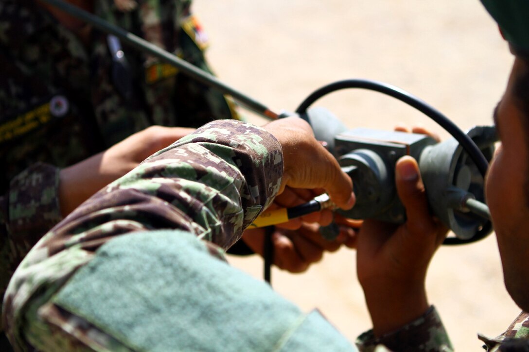 Afghan National Army soldiers with the Signals Kandak, 215th Corps, assemble a radio antenna during training here, July 1, 2013. The Afghan soldiers train to learn antenna communications so they can be ready for any situation, said Staff Sgt. Leo Tapia, the radio chief with the Signals Kandak Adviser Team.