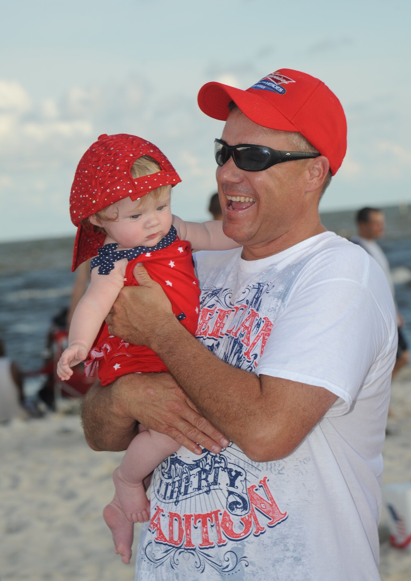 Lt. Col. Jeffrey McLemore, 81st Training Group, holds his daughter during Keesler’s 4th of July Beach Bash, July 4, 2013, on the Biloxi Beach.  The event, held in honor of our nation’s Independence Day, included food, games, music, contests and fireworks.  (U.S. Air Force photo by Kemberly Groue)