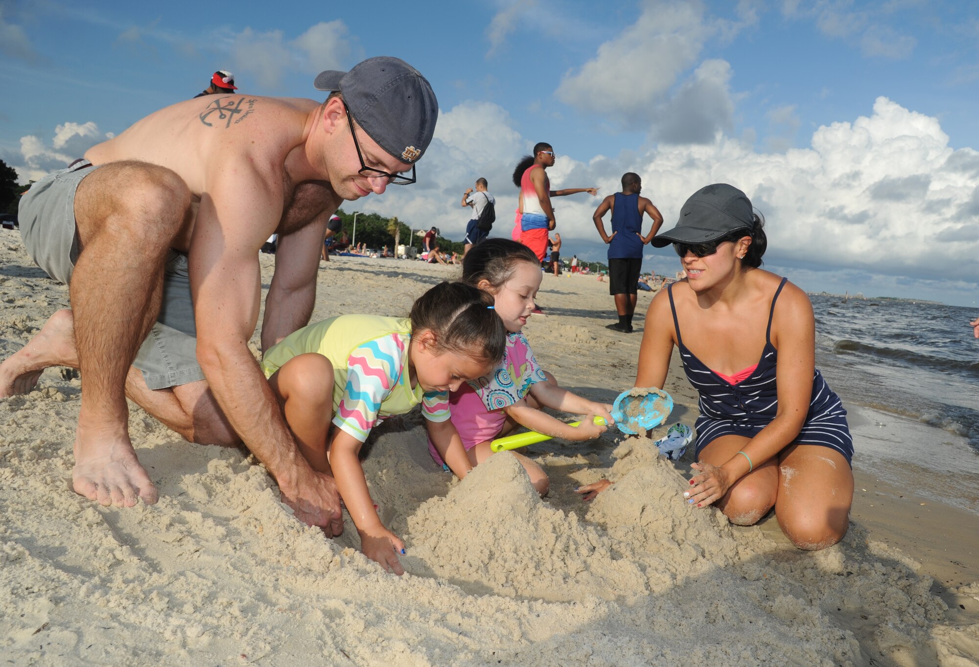 Capt. Mark Coomes, 81st Surgical Operations Squadron, and his family build sand castles during Keesler’s 4th of July Beach Bash, July 4, 2013, on the Biloxi Beach.  The event, held in honor of our nation’s Independence Day, included food, games, music, contests and fireworks.  (U.S. Air Force photo by Kemberly Groue)