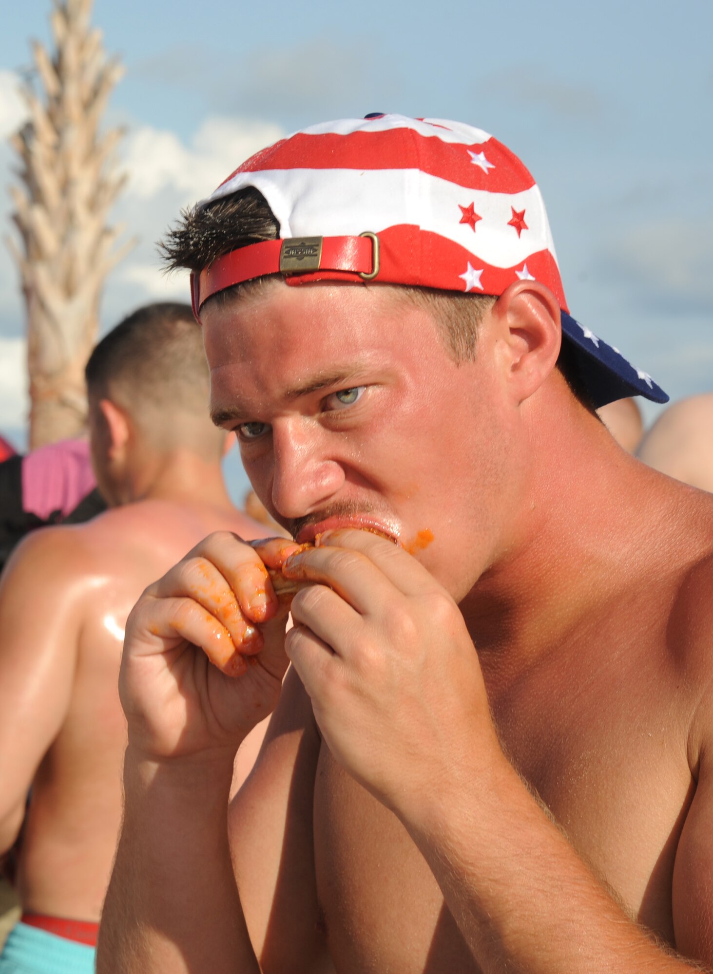 Airman 1st Class Kendall Davis, 335th Training Squadron, eats a chicken wing during Keesler’s 4th of July Beach Bash, July 4, 2013, on the Biloxi Beach.  The event, held in honor of our nation’s Independence Day, included food, games, music, contests and fireworks. (U.S. Air Force photo by Kemberly Groue)