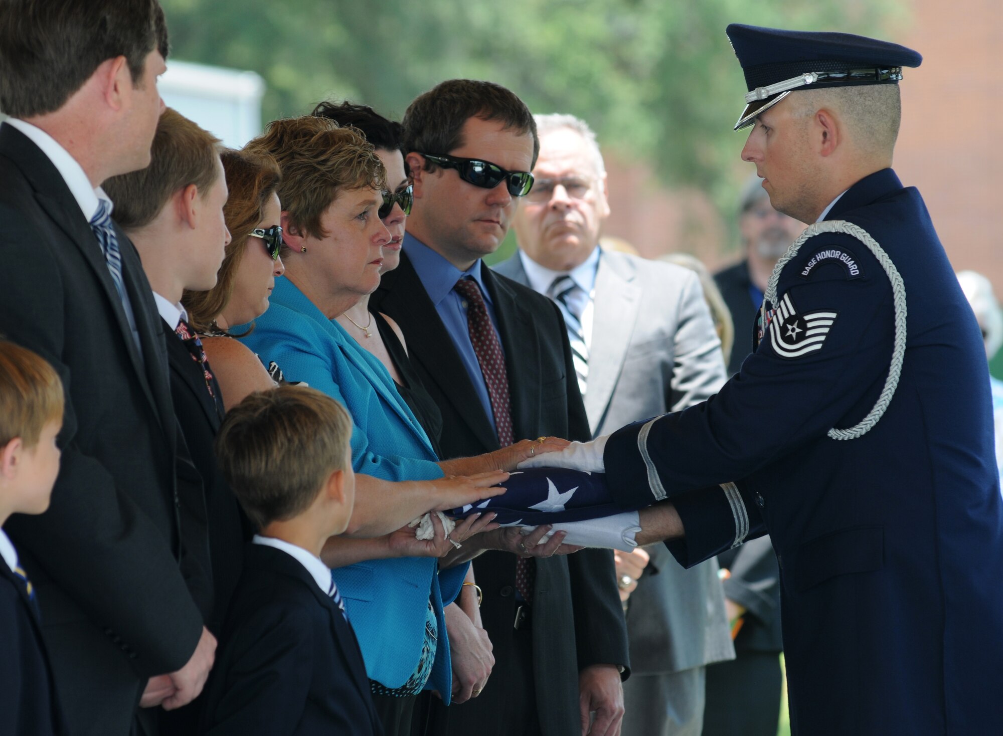 Tech. Sgt. Jonathan Okeefe, Keesler Honor Guard, presents the U.S. flag to the family members of Chief Master Sgt. John Madden, retired, during a funeral service July 2, 2013, at the Biloxi National Cemetery in Biloxi, Miss.  The Keesler Honor Guard’s primary mission is to render military honors for our nation’s fallen service members.  They also support other ceremonial functions such as saber/sword cordons, parades, posting of the colors at retirements, change of commands, prisoner of war/missing in action honors, weddings, sporting events and venues within the local community.  (U.S. Air Force photo by Kemberly Groue)