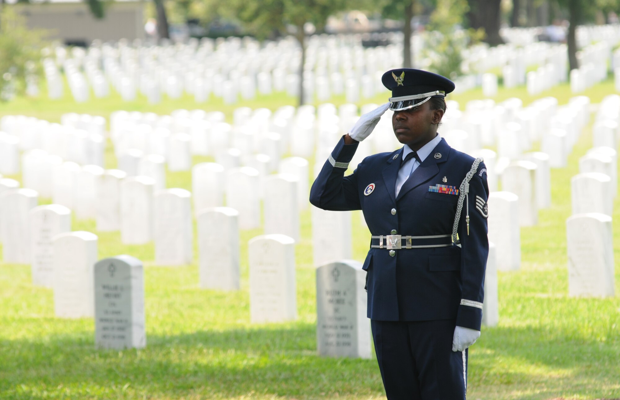 Staff Sgt. Giovanna Gladney, Keesler Honor Guard, salutes during a funeral service July 2, 2013, at the Biloxi National Cemetery in Biloxi, Miss.  The Keesler Honor Guard’s primary mission is to render military honors for our nation’s fallen service members.  They also support other ceremonial functions such as saber/sword cordons, parades, posting of the colors at retirements, change of commands, prisoner of war/missing in action honors, weddings, sporting events and venues within the local community.  (U.S. Air Force photo by Kemberly Groue)