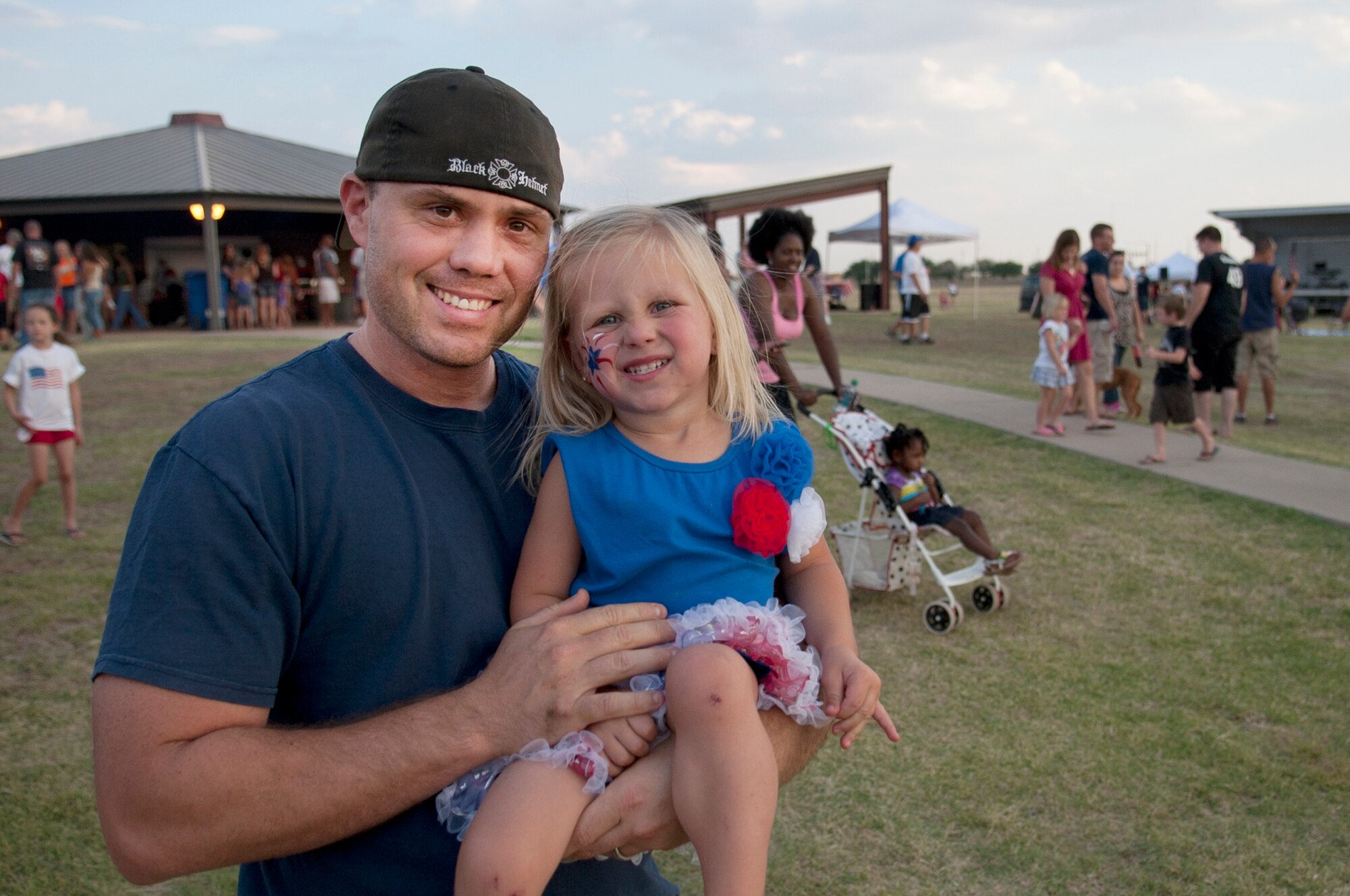ALTUS AIR FORCE BASE, Okla. – Tech. Sgt. Justin Pratt, 97th Maintenance Directorate KC-135 Stratotanker sortie flight maintainer, and daughter Leah, pose for a photograph after visiting the face-painting booth at Excellence Park, July 4. The 4th of July celebration offered free food, live music, children’s inflatable play places and seating for the City of Altus fireworks show. (U.S. Air Force photo by Senior Airman Dillon Davis/Released)