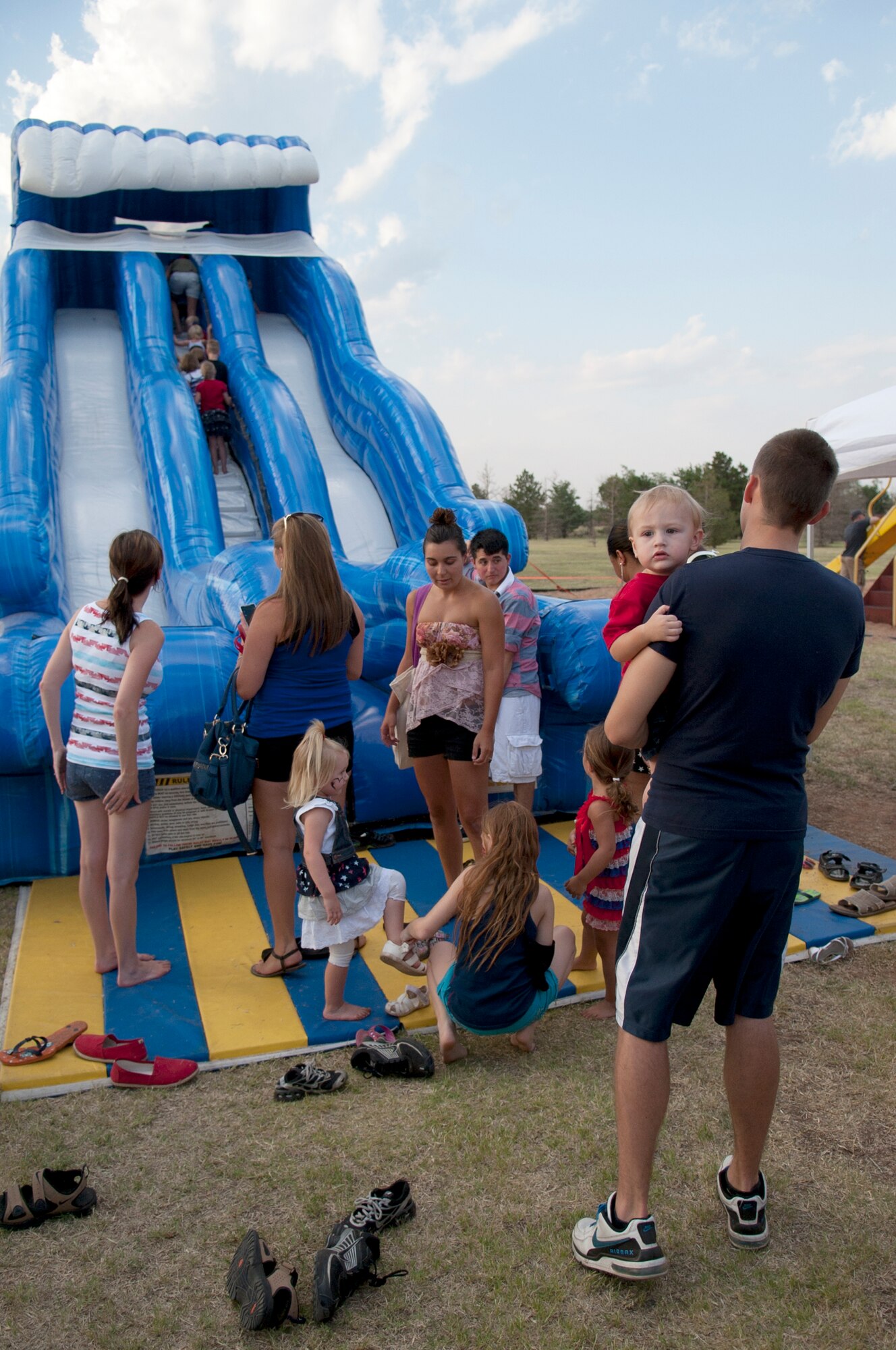 ALTUS AIR FORCE BASE, Okla. – Local children take turns riding down an inflatable slide at Excellence Park, July 4. The 4th of July celebration organized by various base agencies provided quality entertainment for Altus Airmen and their families. (U.S. Air Force photo by Senior Airman Dillon Davis/Released)
