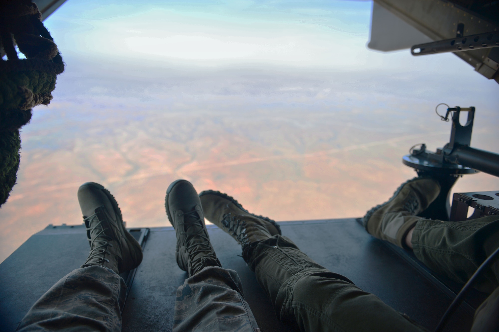 U.S. Air Force members aboard a CV-22 Osprey sit near the rear of the aircraft as it flies over New Mexico, June 25, 2013. Aircrew members viewed the New Mexican terrain from the open rear of the aircraft. (U.S. Air Force photo/Airman 1st Class Eboni Reece)