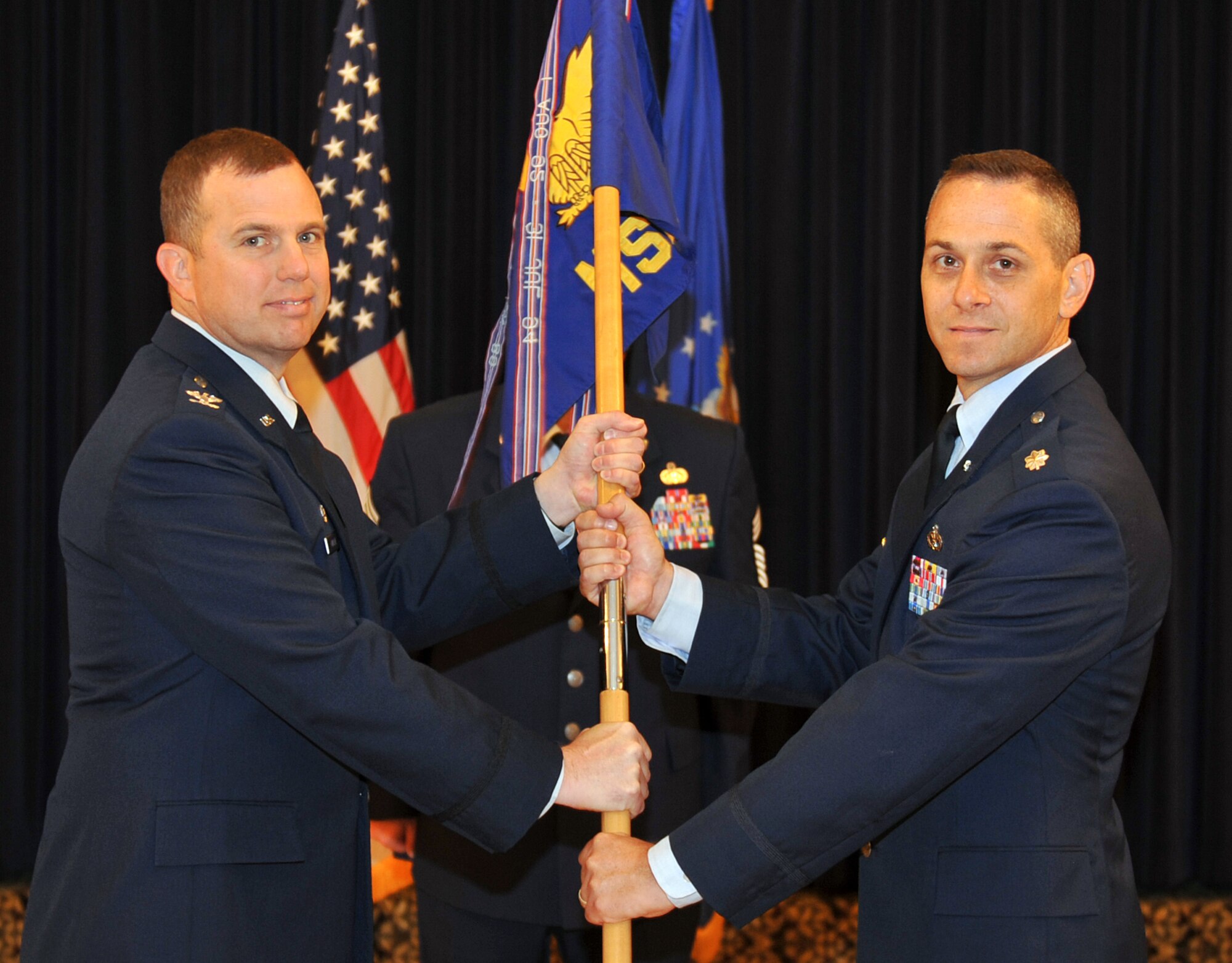 U.S. Air Force Col. Gregory Guillot, 55th Wing commander, hands the 55th
Mission Support Group guidon to U.S. Air Force Lt. Col. Charles Kuhl during
the 55th MSG change of command ceremony July 8 inside the Patriot Club at
Offutt Air Force Base, Neb. Kuhl took command from U.S. Air Force Col.
Andrea Tullos, who had led the group since July 2011. (Air Force photo by
Jeff Gates)
