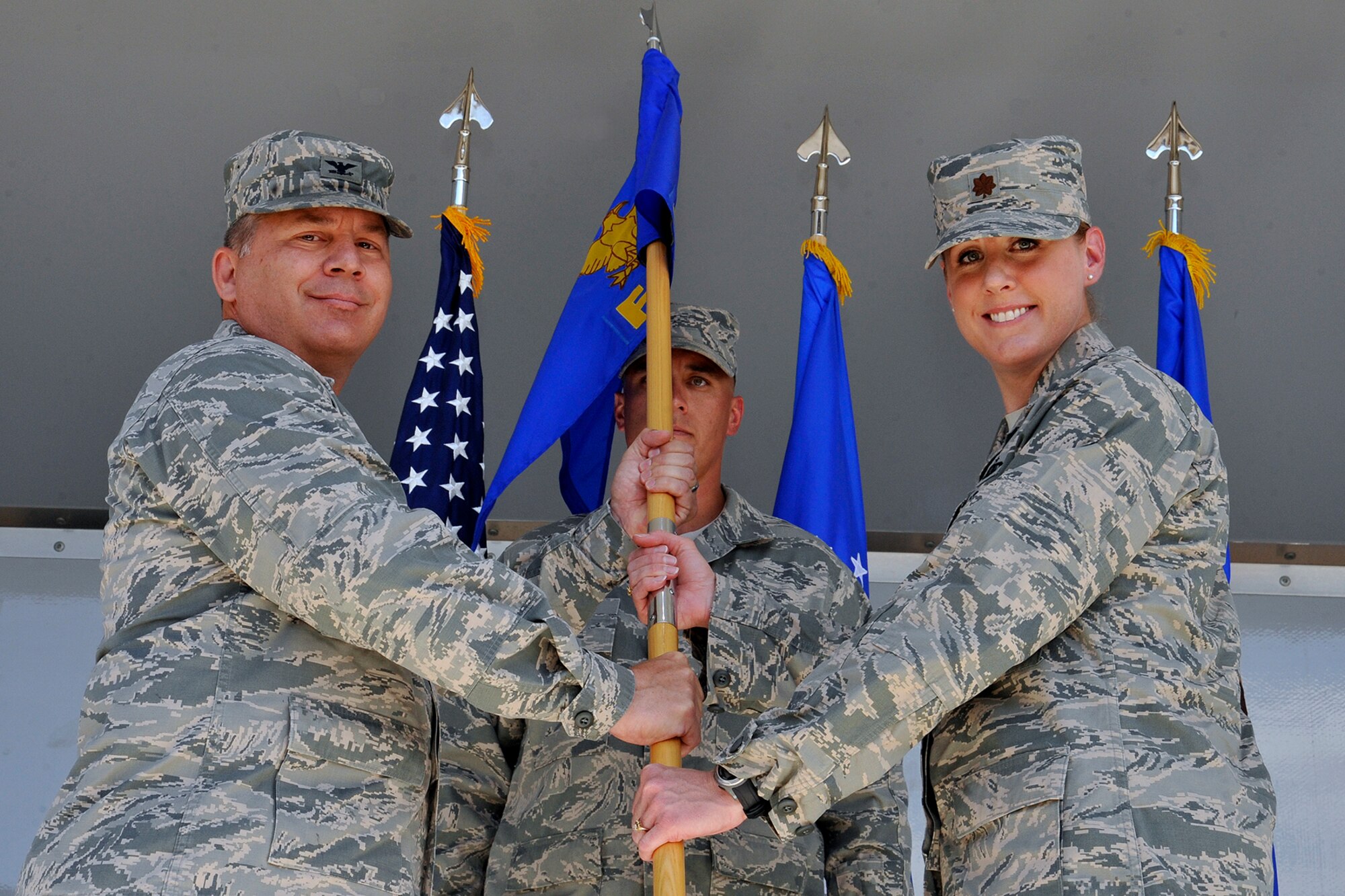 PETERSON AIR FORCE BASE, Colo. – Col. Chuck Arnold (left), 21st Mission Support Group commander, hands the 21st Force Support Squadron guidon to Maj. Tammy Schlichenmaier, incoming 21st FSS commander, during a change of command ceremony July 2 at The Club. Schlichenmaier replaces outgoing commander Lt. Col. Ann Igl. (U.S. Air Force photo/Dennis Howk)