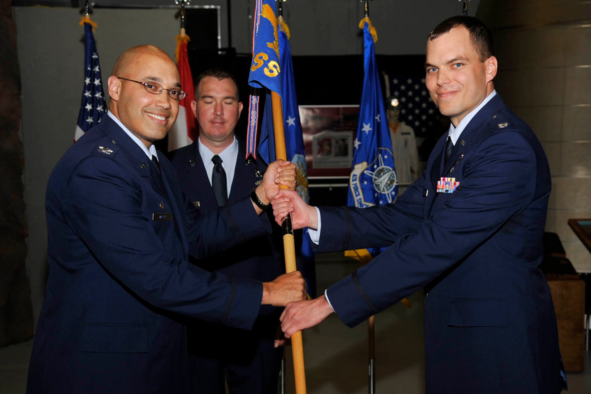 PETERSON AIR FORCE BASE, Colo. – The 21st Operations Support Squadron held its change of command ceremony July 1 at the Peterson Air and Space Museum. Col. David Miller (left), 21st Operations Group commander, passed the squadron guidon to Lt. Col. Robert Hutt, who took command from outgoing commander, Lt. Col. Colin Connor. (U.S. Air Force photo/Robb Lingley)
