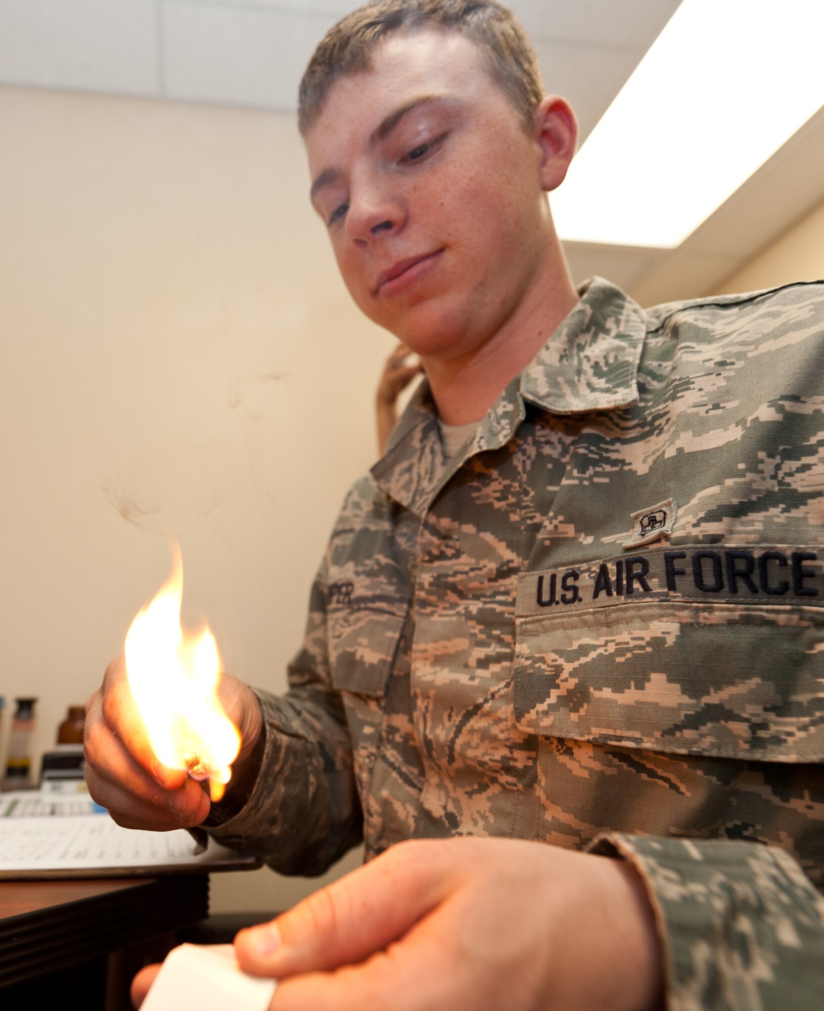 Airman 1st Class Zachary Piper, 28th Medical Operations Squadron bioenvironmental engineering technician, lights a match to create carbon monoxide particles to be evaluated by a Porta Count machine during a gas mask fit test at Ellsworth Air Force Base, S.D., July 1, 2013. The burning of the match creates carbon monoxide so that the machine can count to determine if there are any leaks in the mask, and determine if the mask fits correctly and functions properly. (U.S. Air Force photo by Airman 1st Class Alystria Maurer/Released)
