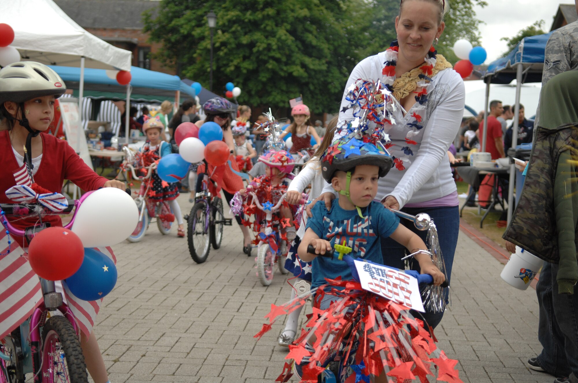 Team Mildenhall children participate in a patriotic bike parade July 3, 2013, during the Independence Day celebration on RAF Mildenhall, England. Children decorated their bikes with streamers, banners and balloons, much like cars and floats do during city-wide parades and county fairs, to celebrate Independence Day. The celebration, similar to an American county fair, was designed to make Airmen feel more at home, while overseas. (U.S. Air Force photo by Airman 1st Class Dillon Johnston/Released)