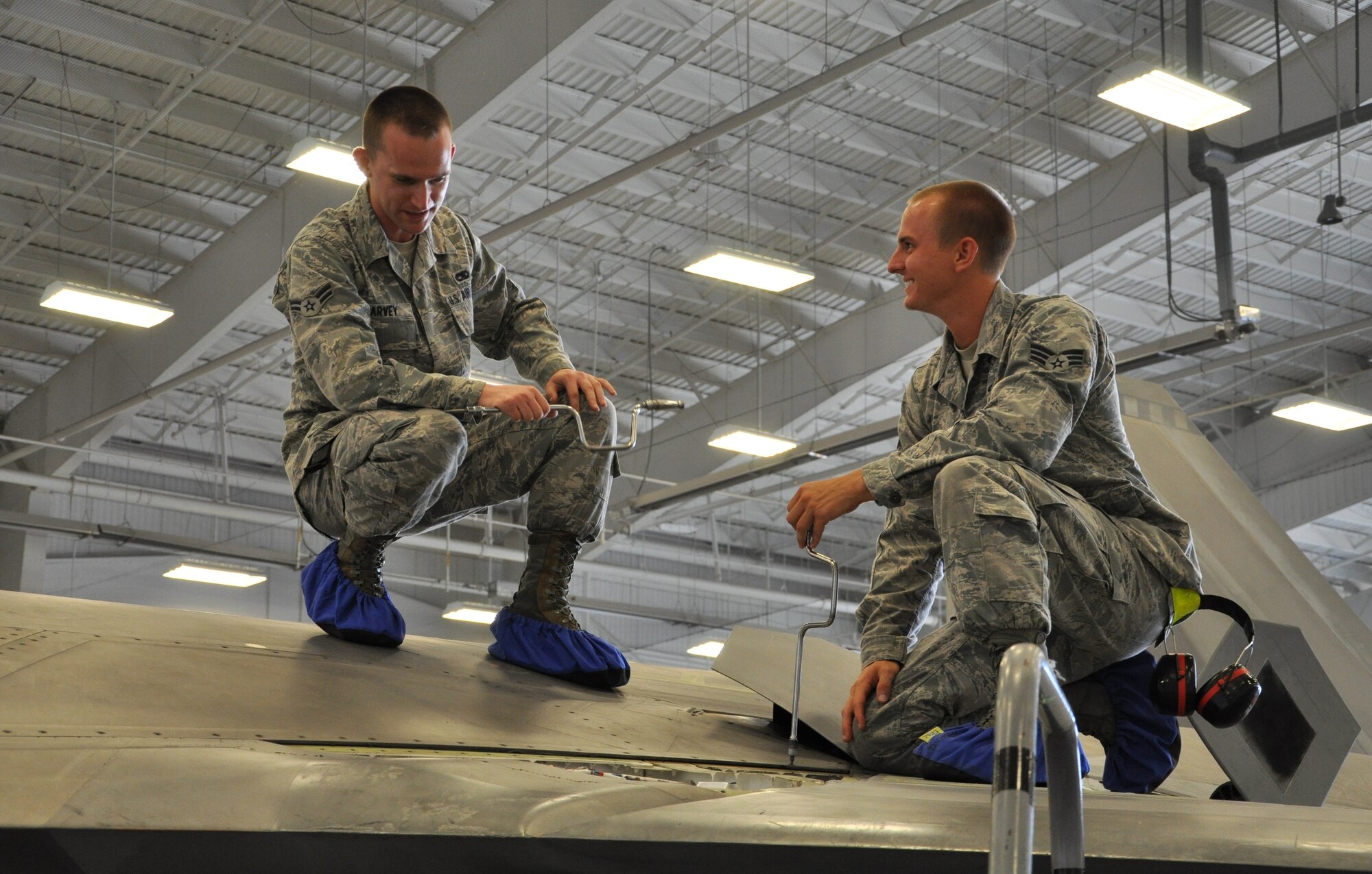 Senior Airman Christopher Dunn, 43rd Aircraft Maintenance Unit F-22 specialist and Airman 1st Class Kenan Harvey, 43rd AMU F-22 specialist, address an issue on top of an F-22 Raptor as part of Avionics Health of the Fleet inside the hangar of the 43rd AMU at Tyndall Air Force Base, Fla. AVHOF is a program implemented to increase the number of fully mission capable F-22s on Tyndall’s flight line. (U.S. Air Force photo by Airman 1st Class Alex Echols)