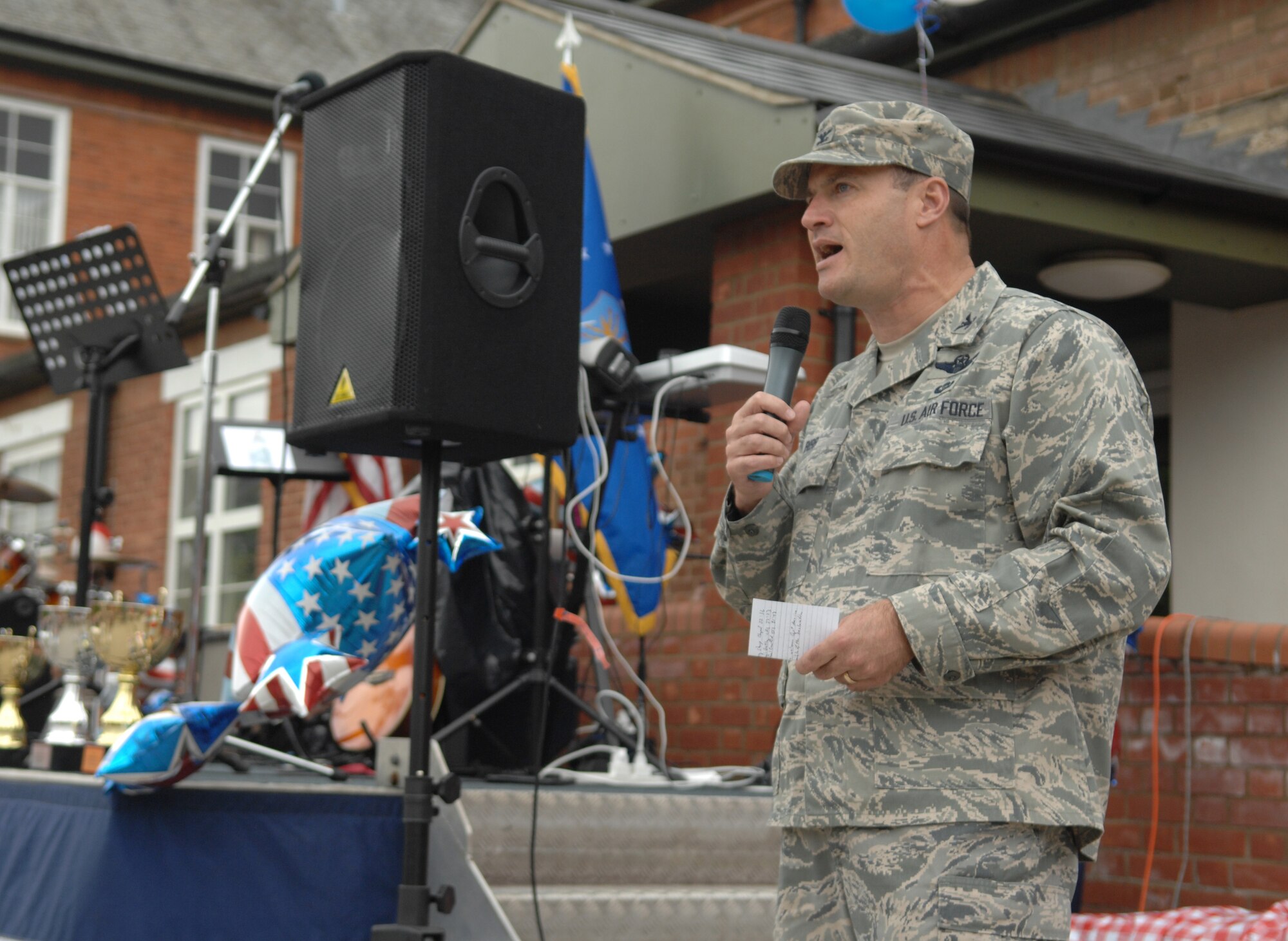 Col. Kenneth T. Bibb Jr., 100th Air Refueling Wing commander, gives opening remarks for the Independence Day celebration July 3, 2013, on RAF Mildenhall, England. Independence Day marks the anniversary of the original 13 colonies declaring independence from British rule in 1776. The celebration, similar to an American county fair, was designed to make Airmen feel more at home while overseas. (U.S. Air Force photo by Airman 1st Class Dillon Johnston/Released)