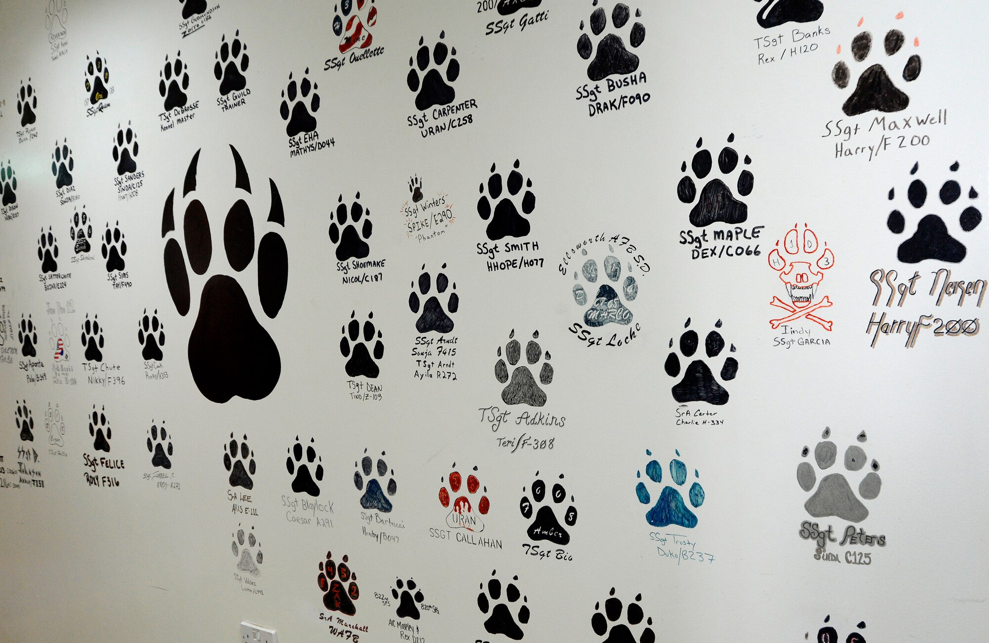 The wall of heroes is displayed at the 386th Expeditionary Security Forces Squadron military working dog flight office here July 2. This wall represents all the current and previous MWDs and their handlers who have been deployed to the 386th Air Expeditionary Wing.  (U.S. Air Force photo by Master Sgt. Christopher A. Campbell)