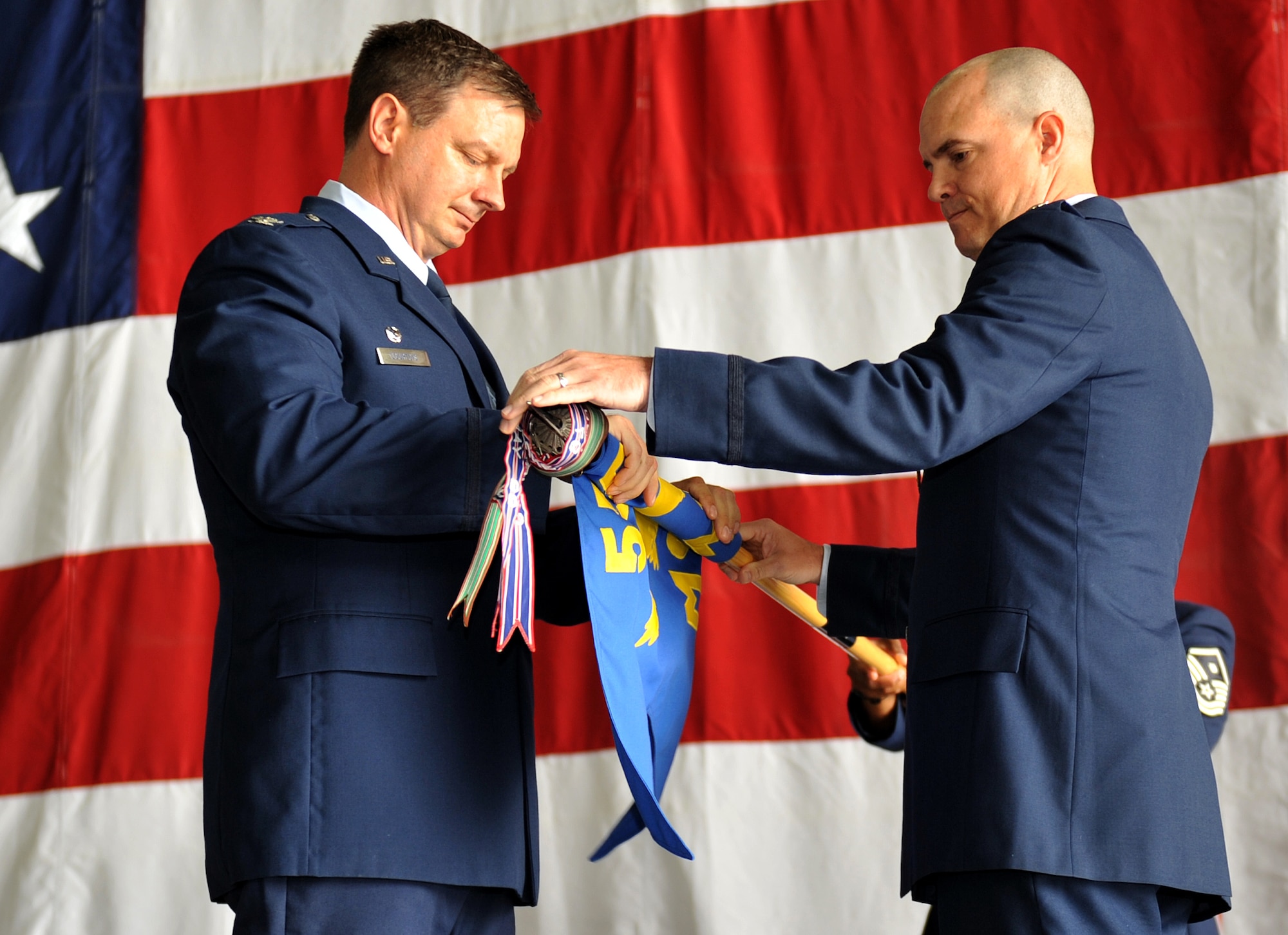 U.S. Air Force Col. Daniel Courtois, 55th Maintenance Group commander, and
Lt. Col. Don Hunt, 55th Maintenance Operations Squadron commander, furl the
55th MOS' guidon during an inactivation ceremony July 2 inside the Bennie
Davis Maintenance Facility Building on Offutt Air Force Base, Neb. The
inactivation of the 55th MOS is part of an Air Force-wide effort to make
available additional field grade officers. For more than 10 years the 55th
MOS managed deployment readiness and maintenance training, including formal,
ancillary and on-the-job training for the maintenance group's approximately
1,100 airmen. (U.S. Air Force photo by Jeff W. Gates/Released)