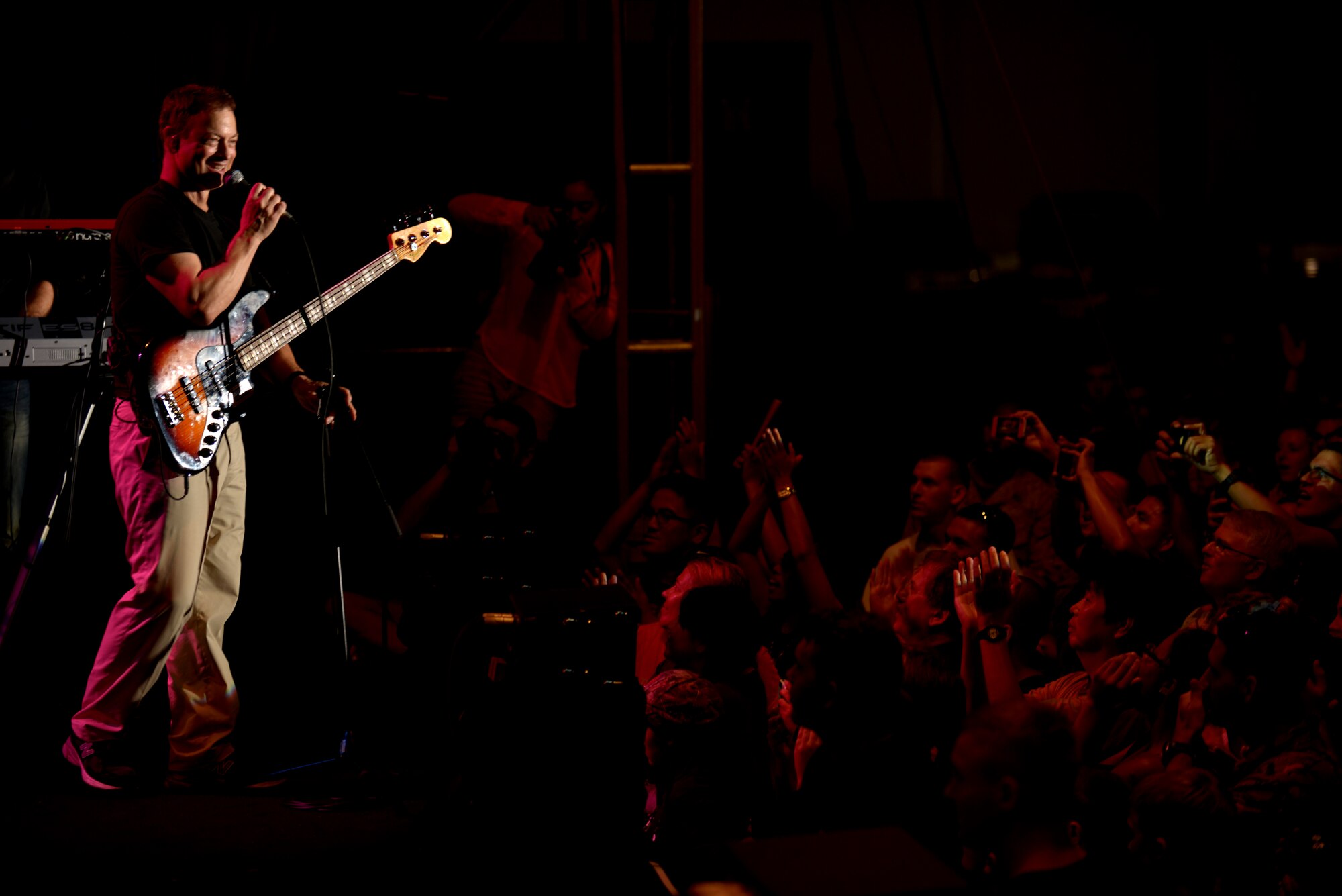 Gary Sinise, actor and bass player for the Lt. Dan Band, talks to the audience during a performance at U.S. Marine Corps Air Station Futenma, Japan, July 6, 2013. This performance was the last in the group's Pacific USO tour. (U.S. Air Force photo by Tech. Sgt. Jocelyn Rich-Pendracki/Released)