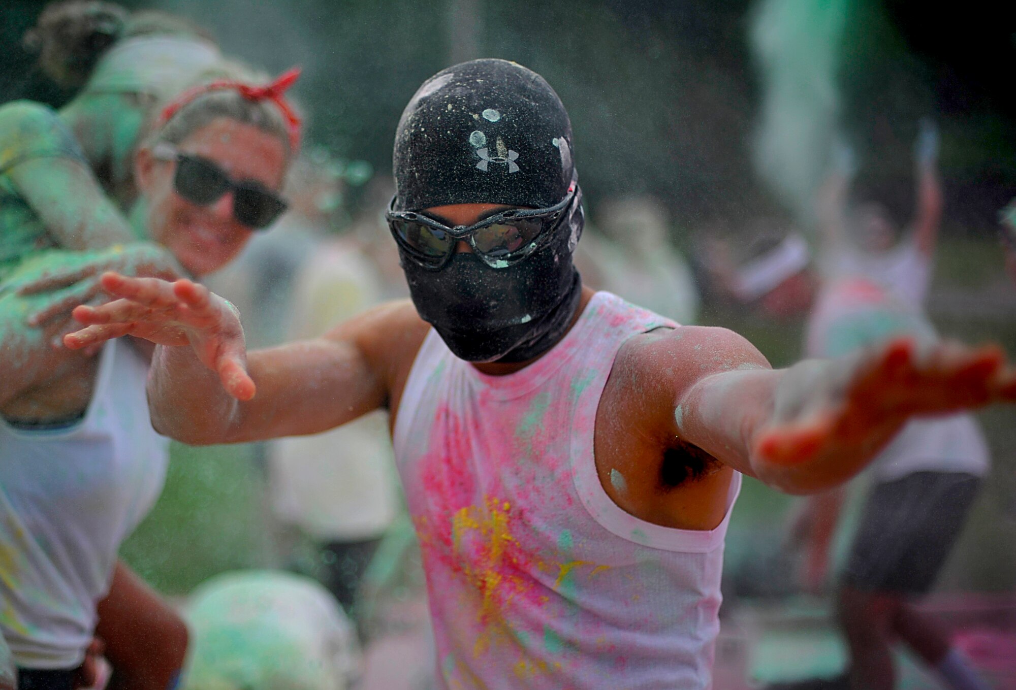 A masked participant in the Freedom Fusion Fun Run reacts after throwing colored corn starch during the event at Osan Air Base, Republic of Korea, July 4, 2013. After all of the participants finished the run, the left over colored corn starch from the color stations was brought to the finish line for everyone to enjoy. (U.S. Air Force photo/Senior Airman Siuta B. Ika)