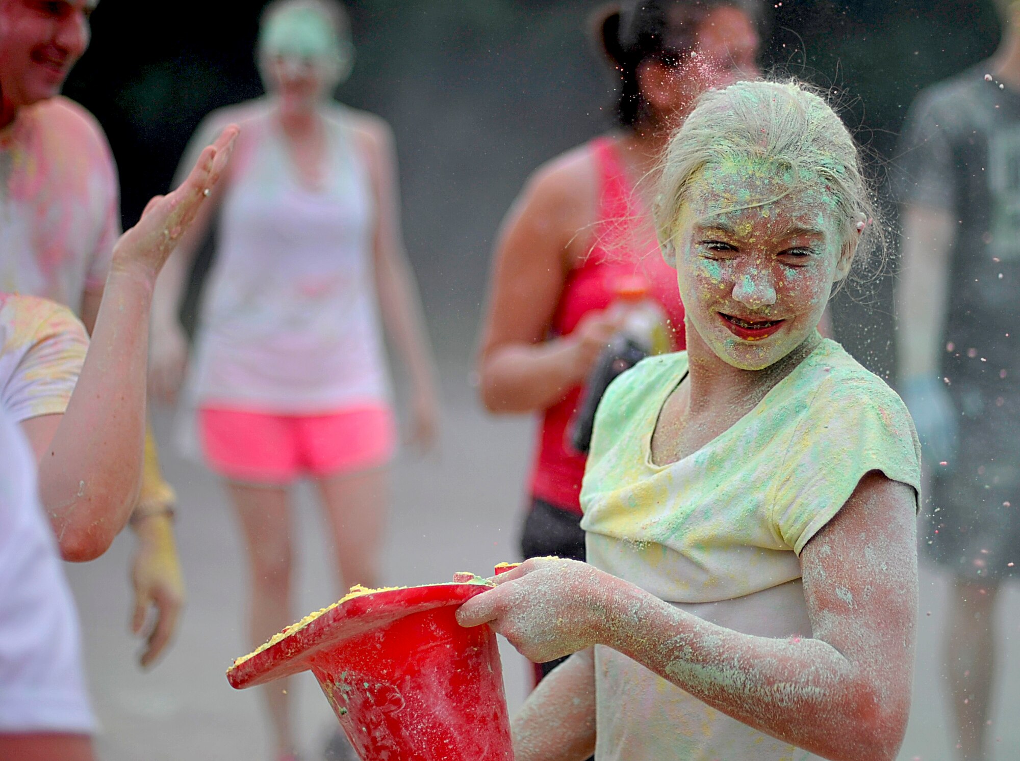 A participant in the Freedom Fusion Fun Run prepares to throw colored corn starch at the fun run’s finishers at Osan Air Base, Republic of Korea, July 4, 2103. The Freedom Fusion Fun Run was based on the color run, a unique paint race that emphasizes fun over competition. (U.S. Air Force photo/Senior Airman Siuta B. Ika)