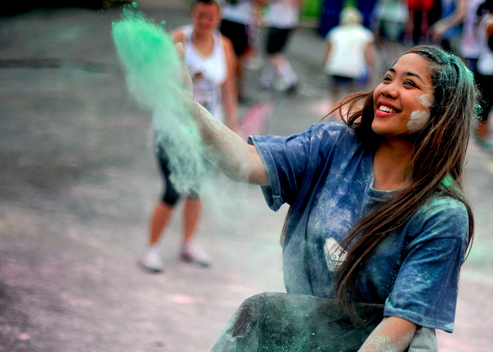 Airman 1st Class Michelle Marasigan, 51st Force Support Squadron fitness specialist, throws colored corn starch during the Freedom Fusion Fun Run at Osan Air Base, Republic of Korea, July 4, 2013. More than 350 people from the Osan community participated in the event that kicked off Osan’s fourth of July celebration. (U.S. Air Force photo/Senior Airman Siuta B. Ika)