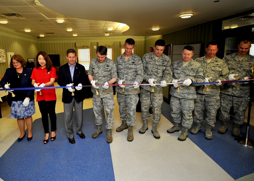 Leadership from the United Services Organization and the 51st Fighter Wing join the 7th Air Force commander, Lt. Gen. Jan-Marc Jouas, in the ribbon cutting ceremony during the USO’s grand opening at Osan Air Base, Republic of Korea, July 3, 2013. The USO’s new location inside the Osan community center will be able to support a larger number of service members and hold larger community events than its previous location. (U.S. Air Force photo/Staff Sgt. Emerson Nunez)