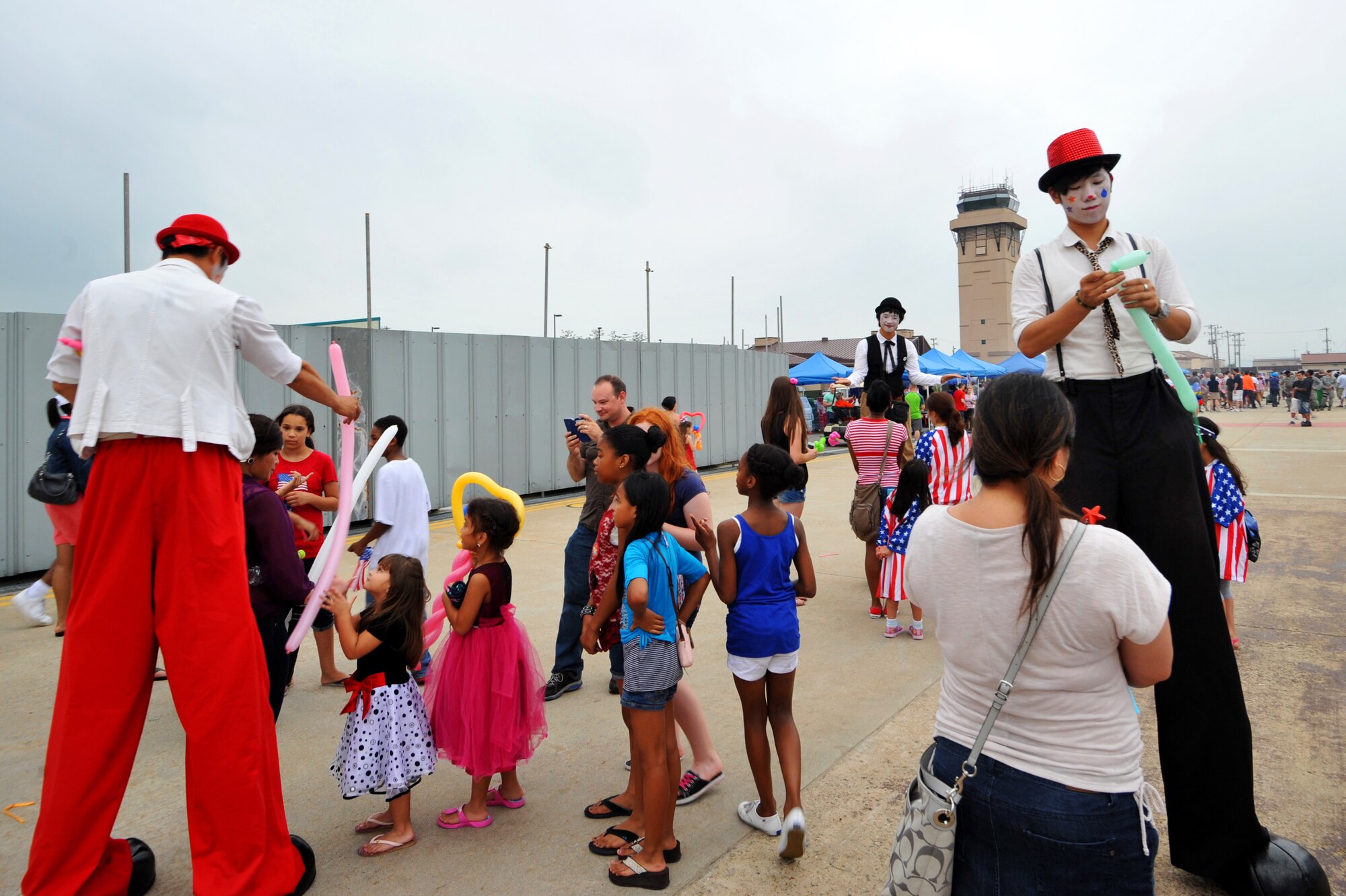 Stilt walkers make balloon animals during Liberty Fest at Osan Air Base, Republic of Korea, July 4, 2013.  The six-hour event on the base operations ramp featured a multitude of entertainment and fireworks provided by 51st Force Support Squadron. (U.S. Air Force photo/Staff Sgt. Emerson Nuñez)
