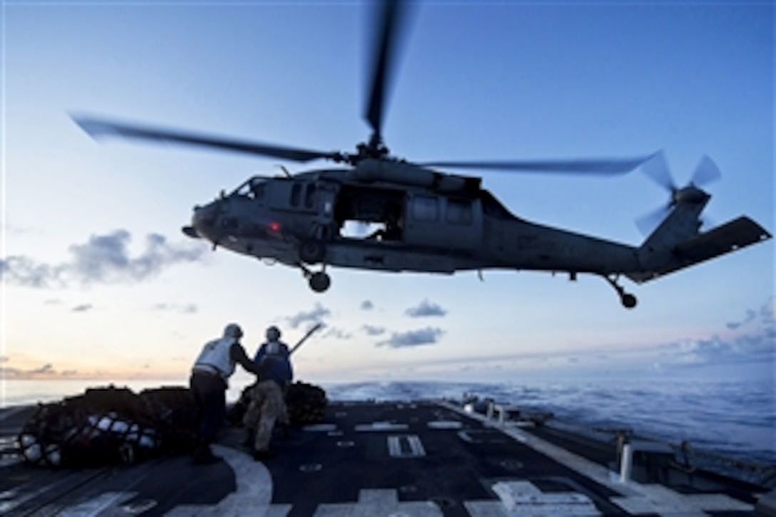 U.S. sailors prepare to attach pallets to an SH-60B Seahawk helicopter during a vertical replenishment on the flight deck of the guided-missile destroyer USS Preble in the Pacific Ocean, July 7, 2013. The Preble is on patrol in the 7th Fleet area of operations supporting security and stability in the Indo-Asia-Pacific region. The helicopter is assigned to Helicopter Anti-Submarine Squadron 49.