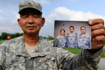 Sgt. 1st Class Andrew Chow, a personnelist with the 205th Infantry Brigade at Camp Atterbury, Ind., holds up a photo of his children, who all currently serve in the Indiana Army National Guard. Pictured (left to right) in the photo are 1st Lt. Petrina Chow, 28, Officer Candidate Philemon Chow, 26, and Spc. Philip Chow, 22.