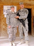 Staff Sgt. Shilo Raulston, the unit movement officer, stands proudly with his spouse, Sgt. Jamie Raulston, the assistant supply sergeant, as she was promoted in February while deployed in Iraq. They are one of 10 married couples, who are members of the 138th Quartermaster Support Company of the Indiana Army National Guard.