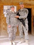 Staff Sgt. Shilo Raulston, the unit movement officer, stands proudly with his spouse, Sgt. Jamie Raulston, the assistant supply sergeant, as she was promoted in February while deployed in Iraq. They are one of 10 married couples, who are members of the 138th Quartermaster Support Company of the Indiana Army National Guard.