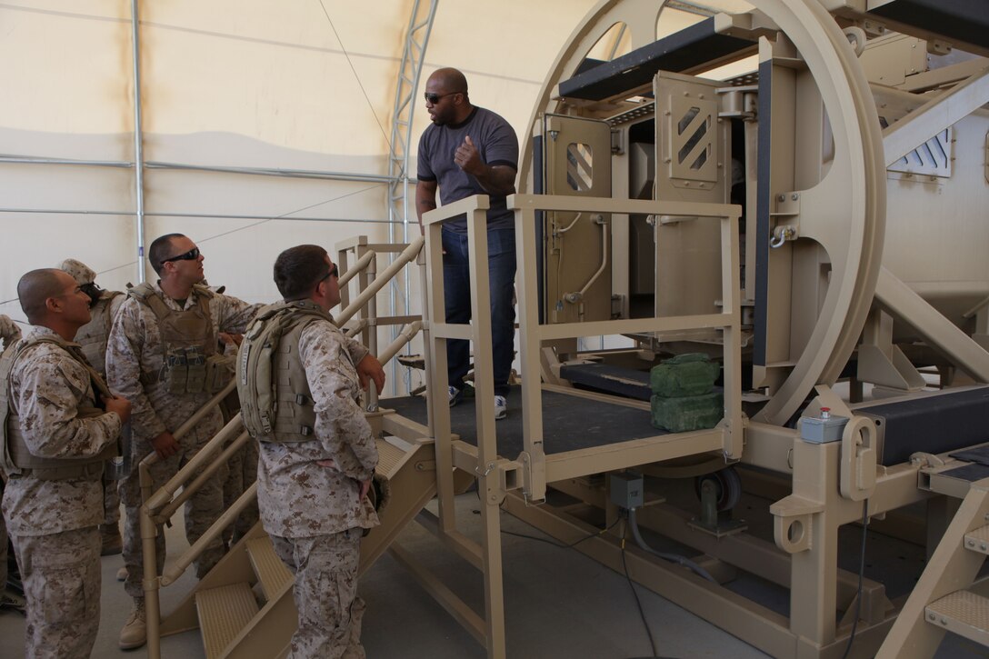 TWENTYNINE PALMS, Calif. – Stan Jenkins, chief instructor for battle simulations, explains how to properly evacuate the Mine-Resistant Ambush Protected Egress Trainer for Marines with Company F, 4th Tank Battalion, 4th Marine Division at the Marine Corps Air Ground Combat Center here June 21. The MRAP egress trainer is used to simulate a vehicle rollover and Marines must evacuate the vehicle quickly and safely. The trainer is part of Integrated Training Exercise 4-13, a cornerstone of the Marine Air Ground Task Force Training Program. It is the largest annual U.S. Marine Corps Reserve training exercise; helping establish best practices, refine planning guidance and baseline requirements for future Reserve units. ITX 4-13, utilizing assets from Ground, Air and Logistic Combat Elements in a live and virtual constructive battalion exercise. (U.S. Marine Corps photo by Cpl. John M. McCall)