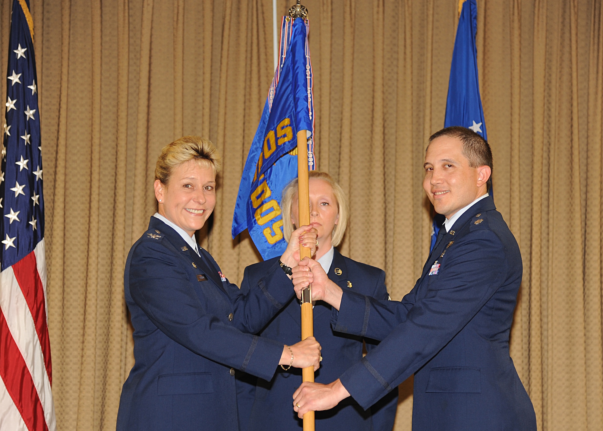 Col. Jane Denton, 319th Medical Group commander, passes the 319th Medical Operations Squadron guidon to Lt. Col. Brett Nishikawa during a change-of-command ceremony July 2, 2013, at Grand Forks Air Force Base, N.D. Nishikawa replaced Lt. Col. Marie Colasanti. (U.S. Air Force photo/ Airman 1st Class Xavier Navarro)
