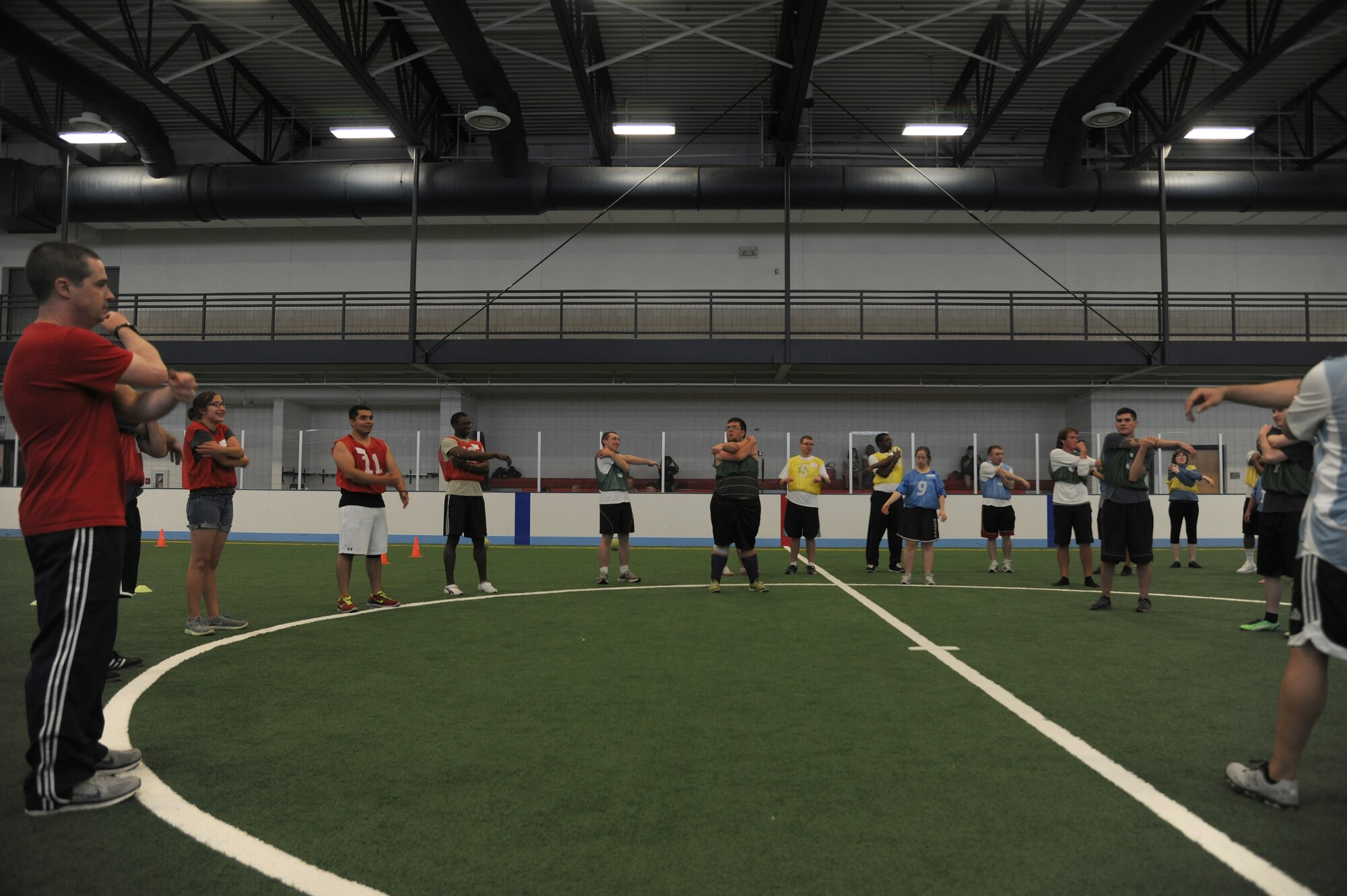 Special Olympic athletes and Airmen from the 319th Air Base Wing warm up before participating in the Unified Soccer Expo, June 26, 2013, on Grand Forks Air Force Base, N.D. Special Olympics uses sports to develop physical fitness, demonstrate courage and participate in sharing gifts, skills and friendship with their families, other athletes and the community. This was the first Special Olympics event held on base since the 1980s, and the event brought Airmen and Special Olympic athletes together to play soccer. (U.S. Air Force photo/Airman 1st Class Ashley Nicole Taylor)  