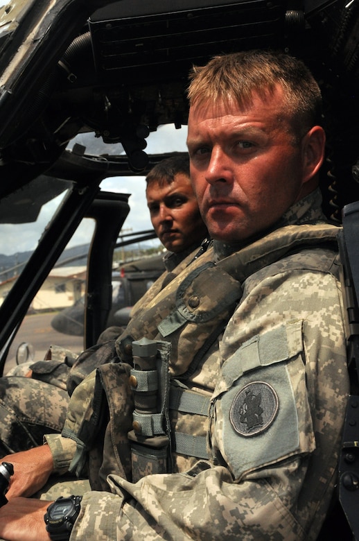 Joint Task Force-Bravo’s 1-228 Aviation Battalion pilot’s U.S. Army Chief Warrant Officer-3 Jay Hanshaw and U.S. Army Warrant Officer-1 Zachary Lugu, pose for a photo inside of a Utility Helicopter-60 (UH-60) here July 9, 2013. The pilots supported U.S. Southern Command’s coordinated search and rescue efforts, which located a stranded vessel and saved the lives of two Americans, one Canadian and six Hondurans, July 3.   