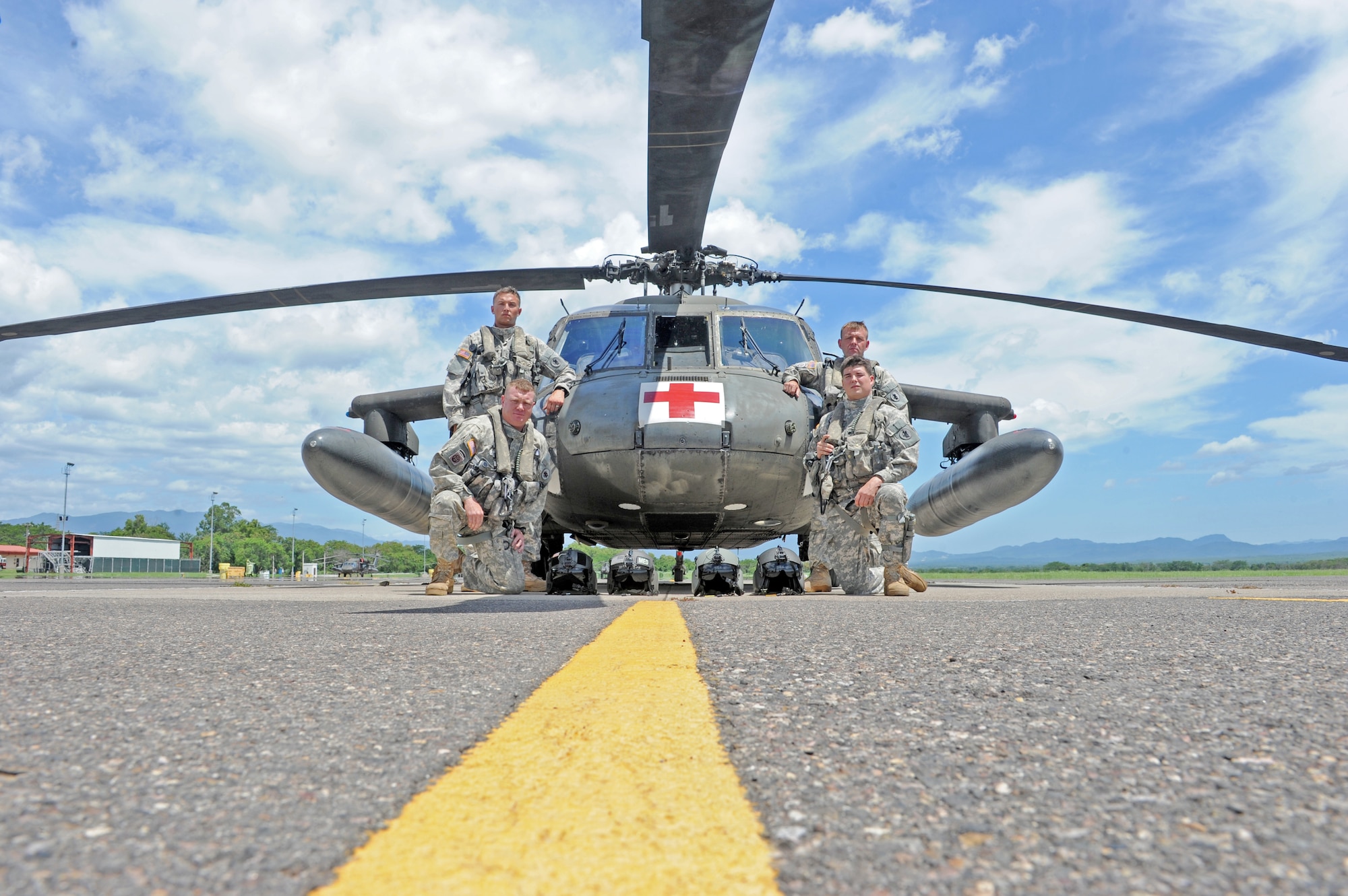 Members of Joint Task Force-Bravo’s 1-228 Aviation Battalion flight crew U.S. Army Warrant Officer-1 Zachary Lugu(top left),pilot,  U.S. Army Sgt. U.S. Army Sgt. Travis Mayo, flight medic(left front), U.S. Army SPC  Robert Clement (right front), crew chief, and U.S. Army Chief Warrant Officer-3 Jay Hanshaw pose for a photo infront of a Utility Helicopter-60 (UH-60) here July 9, 2013. The flight crew supported U.S. Southern Command’s coordinated search and rescue efforts, which located a stranded vessel and saved the lives of two Americans, one Canadian and six Hondurans, July 3.   